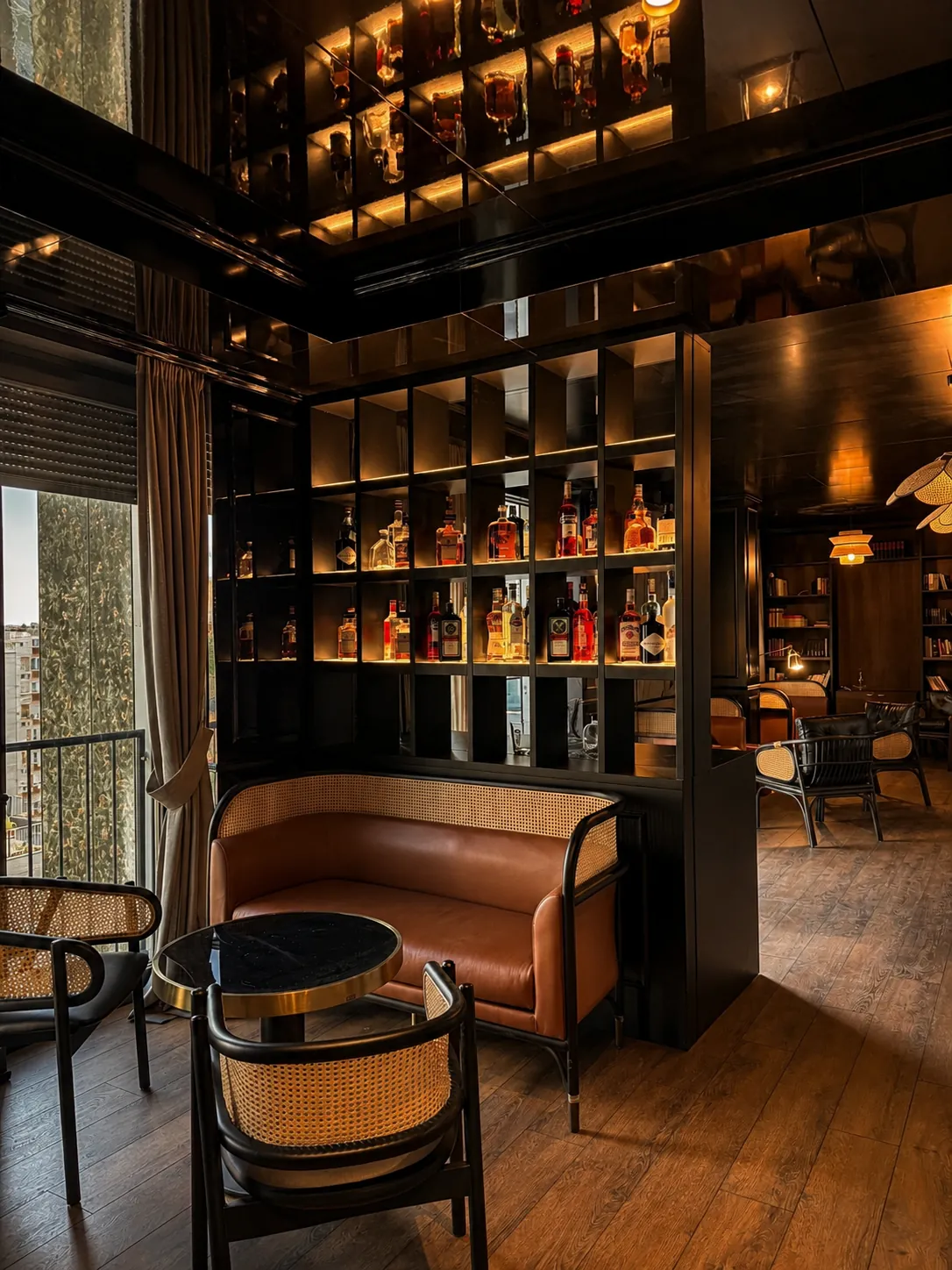 The guests-only lounge bar at Lusso hotel Prishtina, lit shelves of bottles and a balcony